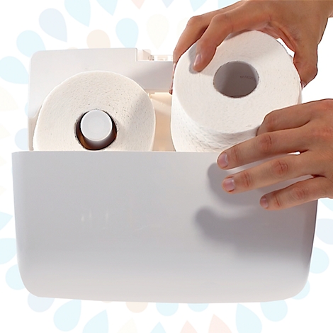 Handen plaatsen een nieuwe rol toiletpapier in een witte toiletpapierhouder.