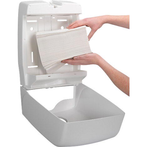 Person loading paper towels into a white paper towel dispenser.
