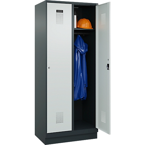 Grauer Schrank mit offener Tür, Innenraum mit Helm und Regenjacke. Die andere Tür ist geschlossen.