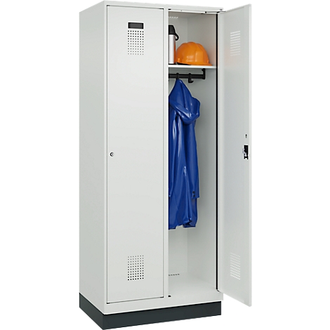 Weißer Stahlschrank, eine Tür geöffnet. Im Inneren ein blauer Regenmantel, ein Helm und eine Trinkflasche.