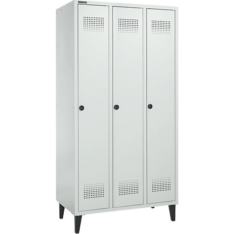 Ein weißer, dreitüriger Schrank mit schwarzen Füßen und Knöpfen, perforierte Lüftungsschlitze.
