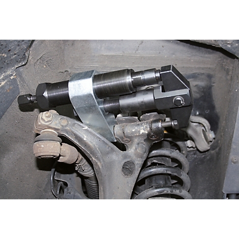 Ein Werkzeug an einem Fahrzeugfahrwerk. Das Werkzeug besteht aus Metall und wird zur Reparatur verwendet.