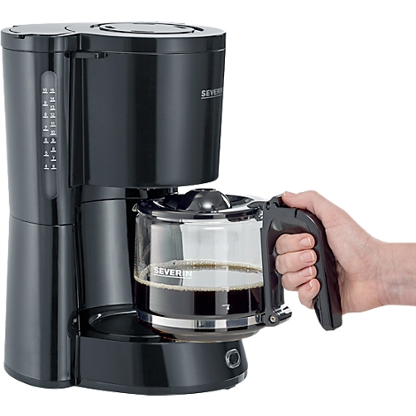 Zwarte koffiemachine met een glazen kan gevuld met koffie. Een hand houdt de handgreep vast.