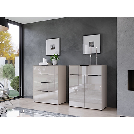 Zwei cremefarbene Sideboards im Wohnzimmer. Rechts Schrank mit Kerzen, links Kommode mit Schubladen, im Hintergrund Fenster.