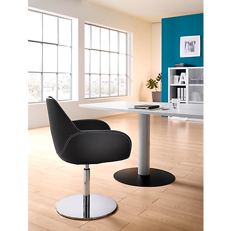 Black office chair, with white seam and chrome foot, in front of window and table.