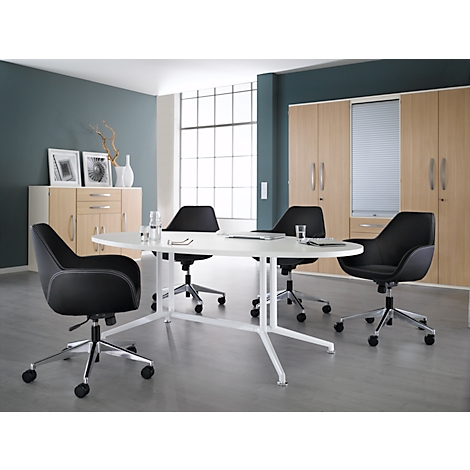 Conference table with black chairs in a modern office. Cabinets and windows in the background.