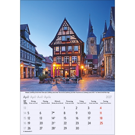 Calendrier d'avril représentant un paysage urbain pittoresque avec des maisons à colombages, des tours et une place. Ambiance du soir avec des bâtiments éclairés.