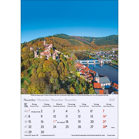 Calendrier montrant un château sur une colline avec des arbres colorés, une rivière et une ville.