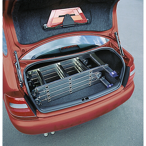 A red station wagon with an open tailgate containing a folded ladder. A warning triangle is attached.
