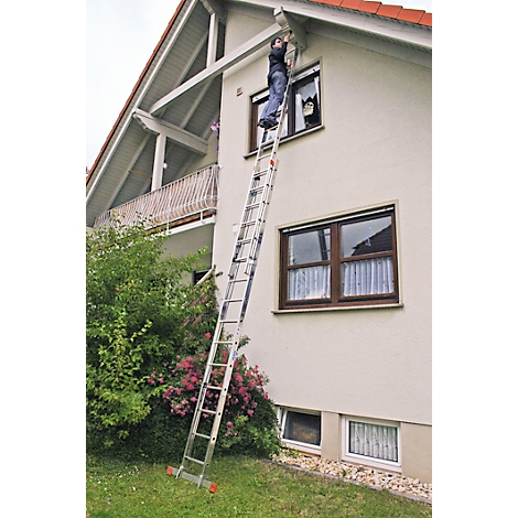Person on a ladder at a house, cleaning the gutter. A cat is in the window.