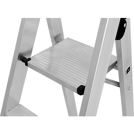 Detailopname van een zilverkleurige trap, met een getextureerde trede en zwarte verbindingsstukken.