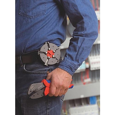 Man in spijkerbroek en blauw overhemd, houdt rode en blauwe tang vast. Op de riem een gereedschapstas met een rond element.