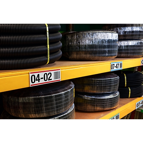 Black corrugated hoses on shelves. Labels with numbers and barcodes are visible.