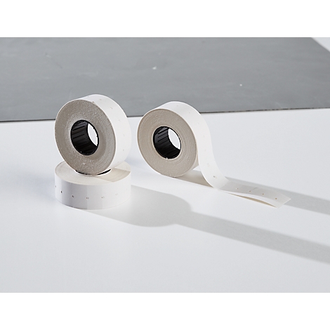 Three rolls of white label tape. One roll is lying down, two are standing and casting shadows on a white surface.