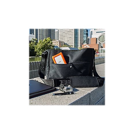 Schwarze Umhängetasche mit Festplatte, Tablet, Stift, Kamera. Im Hintergrund Gebäude.