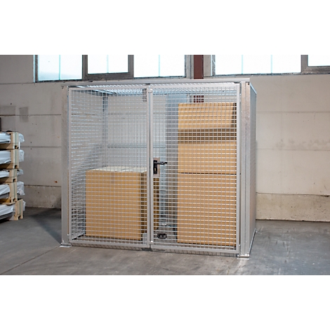 Metallgitter-Schrank mit Kartons. Gittertür mit Schloss, steht in Lagerhalle.