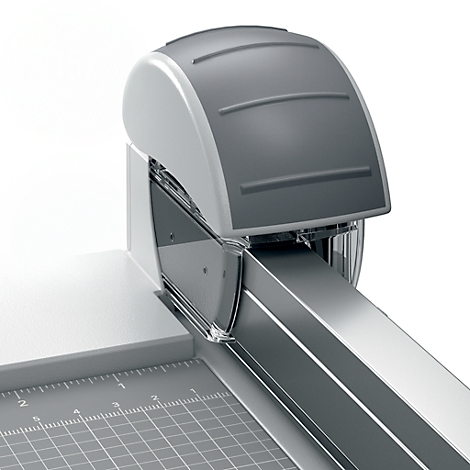 Gros plan d'une coupe-papier grise. La tête de coupe est arrondie avec des lignes horizontales. La lame est visible et la base a un motif à carreaux.