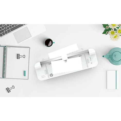 Bovenaanzicht van een bureau met een printer, laptop, notitieboek, beker, theepot en bloemen. Alle elementen zijn wit of lichtgrijs.