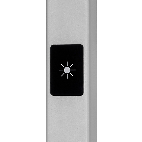 Gros plan d'un appareil argenté avec un rectangle noir et un symbole de lumière.
