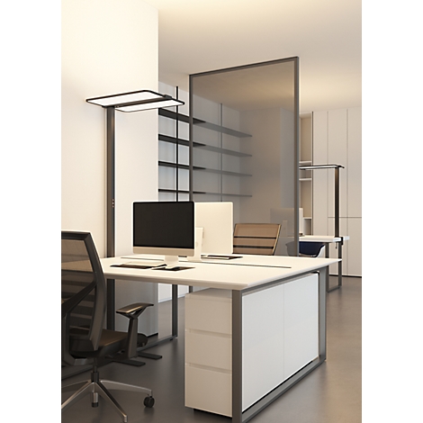 Bureau moderne avec des bureaux blancs, des chaises de bureau noires et un lampadaire devant une cloison.