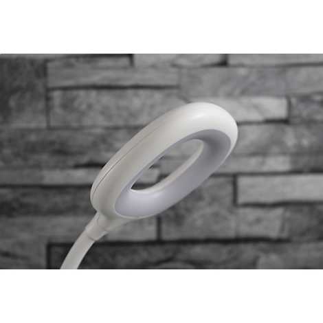 Détail d'une lampe de bureau à LED blanche, tête de lampe en forme d'anneau, fond gris.