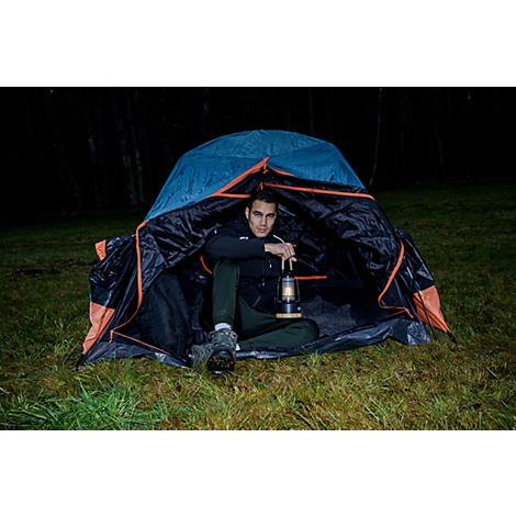 Une lampe portable moderne avec un panier en fil métallique noir. La base est en bois clair, avec un port USB visible. Un câble noir sort de la lampe.