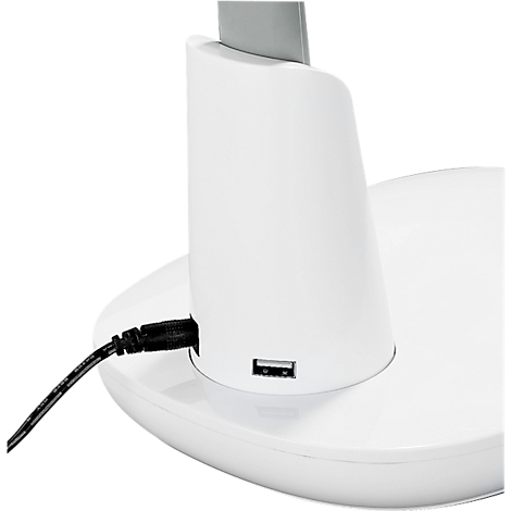 Gros plan d'une lampe de table blanche. Le port USB et le connecteur d'alimentation sont visibles. Un câble noir est connecté.