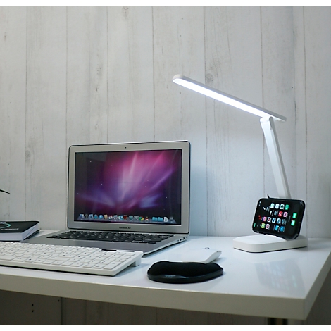 Bureau blanc avec ordinateur portable, clavier, souris, lampe et smartphone avec applications.