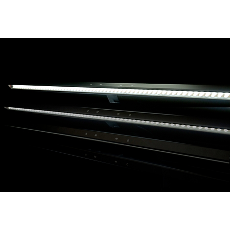 Trois lumières LED allongées et lumineuses sur fond noir. La lumière supérieure est la plus brillante, les autres se reflètent en dessous.