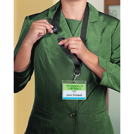 Femme en blazer vert tenant un cordon noir avec badge nominatif. Le badge indique "Sustainability Conference", nom : Jane Kimbell.