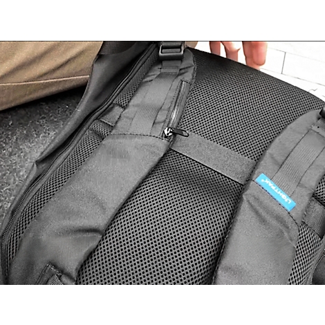 Zwarte rugzak met mesh rug. Schouderbanden, een rits en een blauw label zijn zichtbaar.