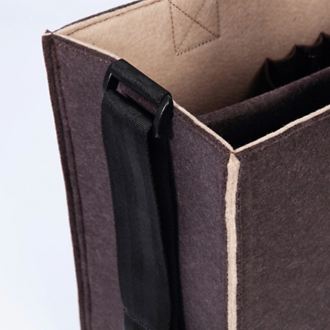 Detailopname van een bruine vilten tas met een zwarte schouderriem en beige voering.