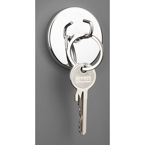 A keychain with a door key hangs from a round, silver-colored magnet on a gray background.