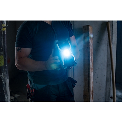 Tragbare LED-Arbeitslampe mit schwarzem und silbernem Gehäuse, rundem Lichtmittel in der Mitte.