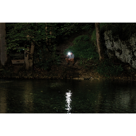 Black flashlight with yellow button, side clip, and carrying strap.