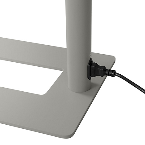 Detailaufnahme: Stromanschluss an einer grauen Metallkonstruktion. Ein schwarzes Netzkabel ist eingesteckt.