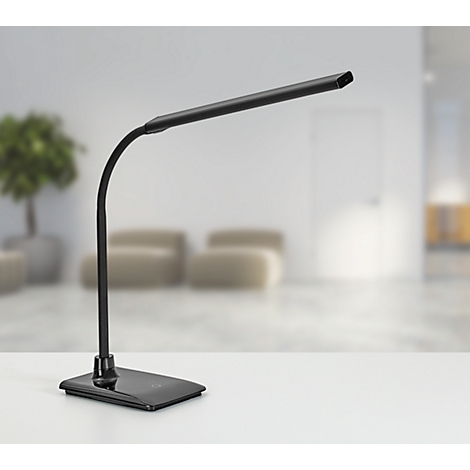 Zwarte bureaulamp op witte tafel. Achtergrond met wazige woonkamer.