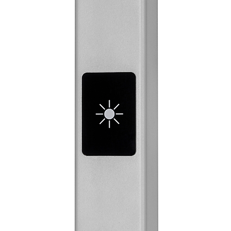 Close-up van een zilverkleurig apparaat met een zwarte knop met een lichtsymbool.