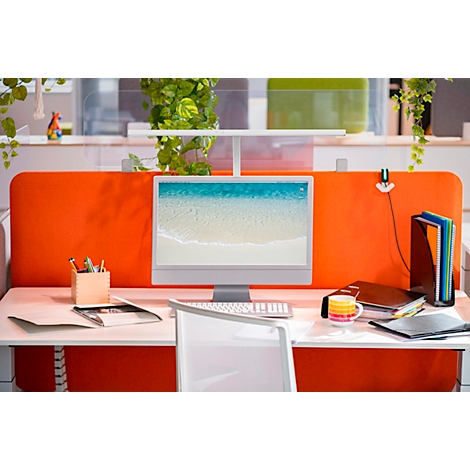 Kantoorwerkplek met oranje scheidingswand, computer, bureau-accessoires en planten.