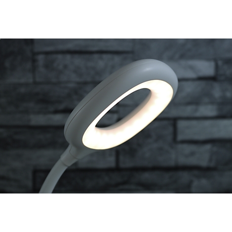 Nahaufnahme einer weißen LED-Schreibtischlampe mit einem leuchtenden, kreisförmigen Lampenkopf.