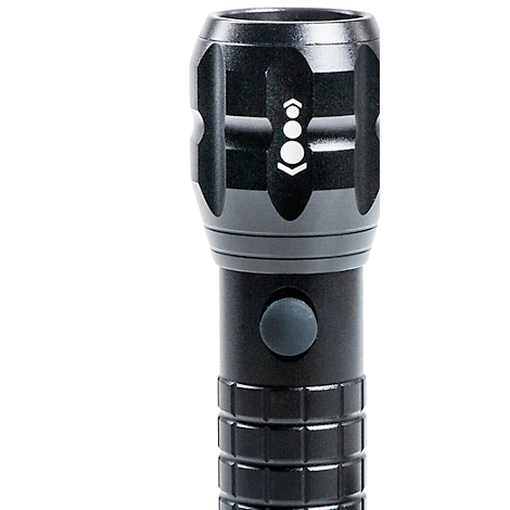 Close-up of a black flashlight with a switch and markings. The top has an arrangement of dots and arrows.