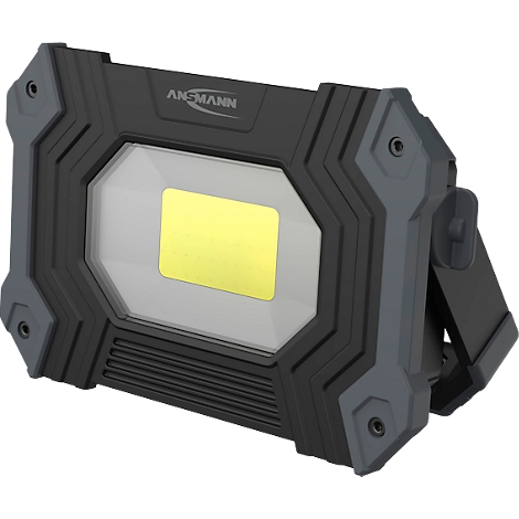 A sturdy LED construction lamp, grey and black. A yellow rectangle shines in the middle. The brand name 'ANSMANN' is visible.