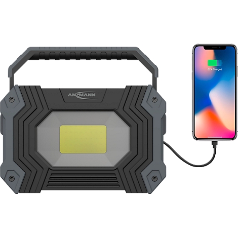Black and gray construction lamp with yellow light, charging a smartphone.