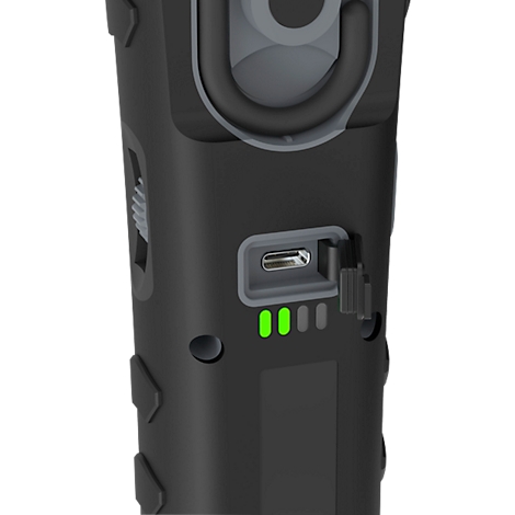 Detail of a black flashlight. Green charging indicator lights up and USB-C port visible.