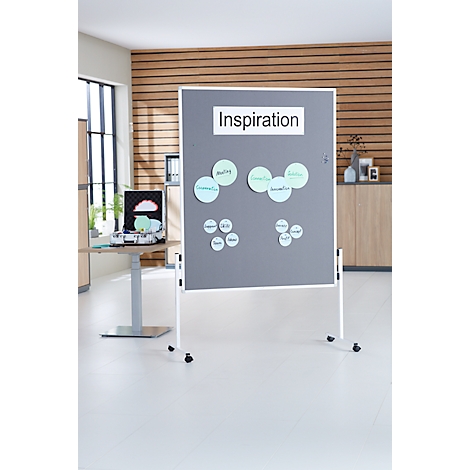 Grijs prikbord met "Inspiration" opschrift en notitielabels, voor een houten wand. Verrijdbare poten.