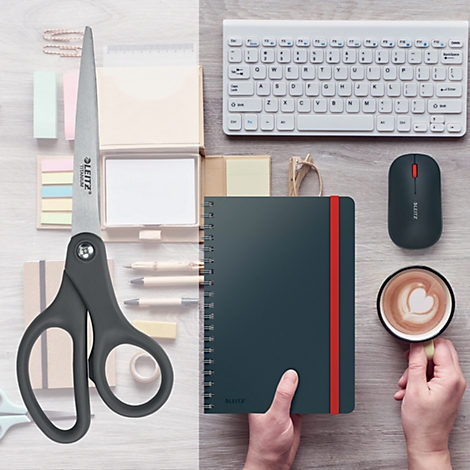 Vue de dessus d'un bureau avec des ciseaux, un cahier, une souris, un clavier, du café.
