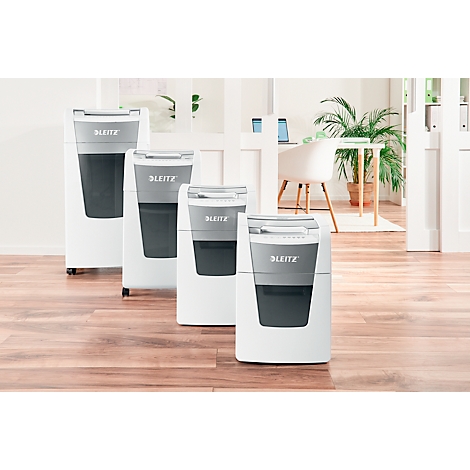 Four shredders in a row, white, gray, with the "Blitze" logo. In the background, an office with a desk and plant.