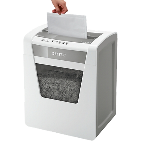 A hand feeds paper into a white Leitz shredder. The collection bin is full.