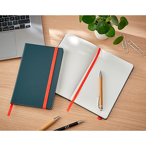 Groen notitieboek met rode bladwijzer. Open notitieboek met geruite pagina's en pen. Op houten oppervlak.