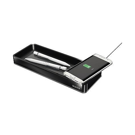 Zwarte bureaubladlade met twee pennen en een smartphone die wordt opgeladen.